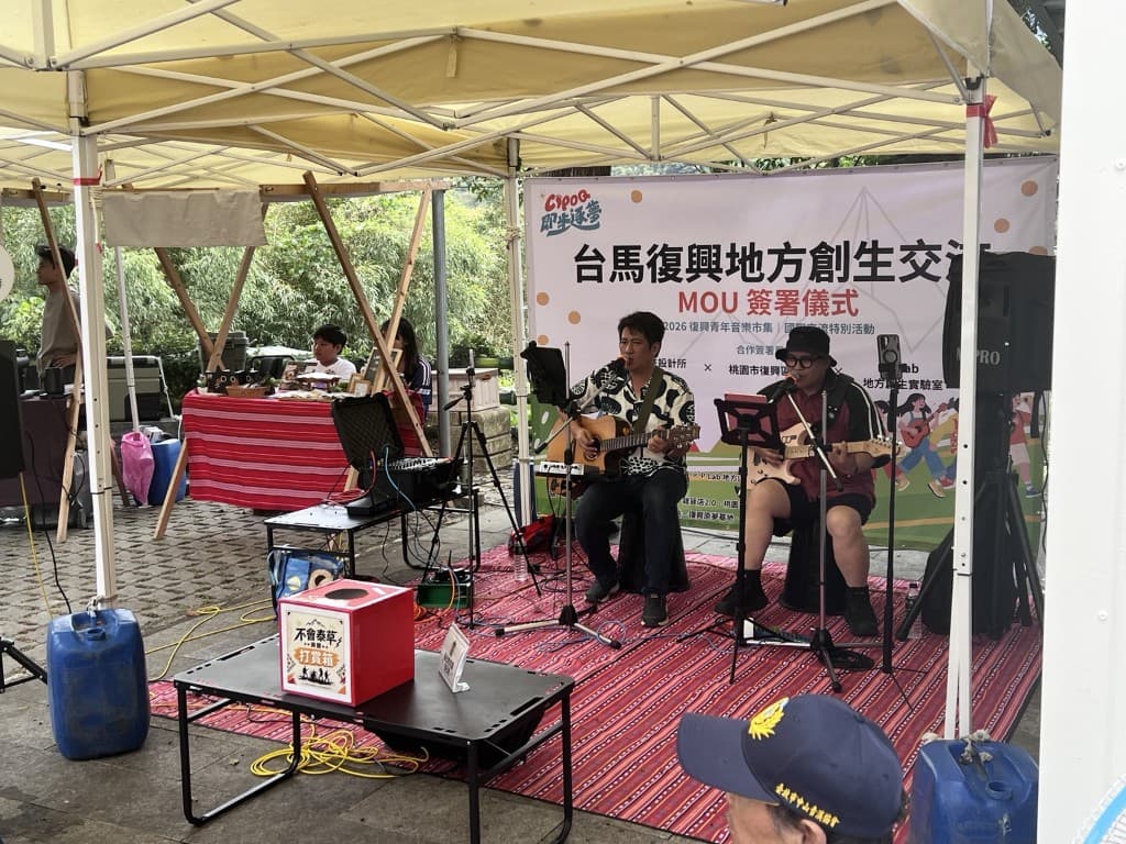 台馬復興地方創生交流現場,兩位音樂人在戶外帳篷舞台上演奏