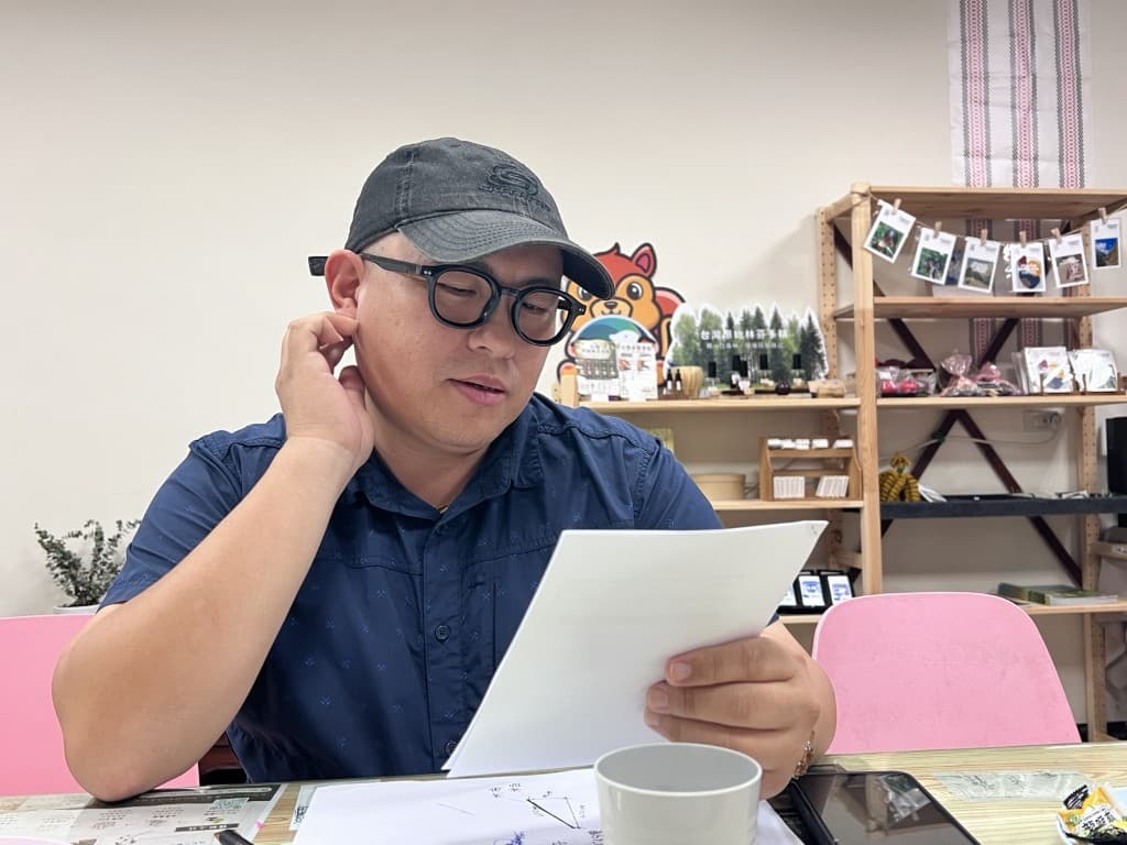 音樂人低頭看著手稿,整理歌詞與創作想法