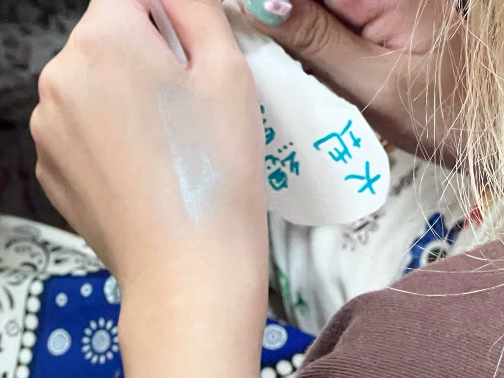 學生手背上留著白色文化圖紋顏料,旁邊是寫著文字的紙張