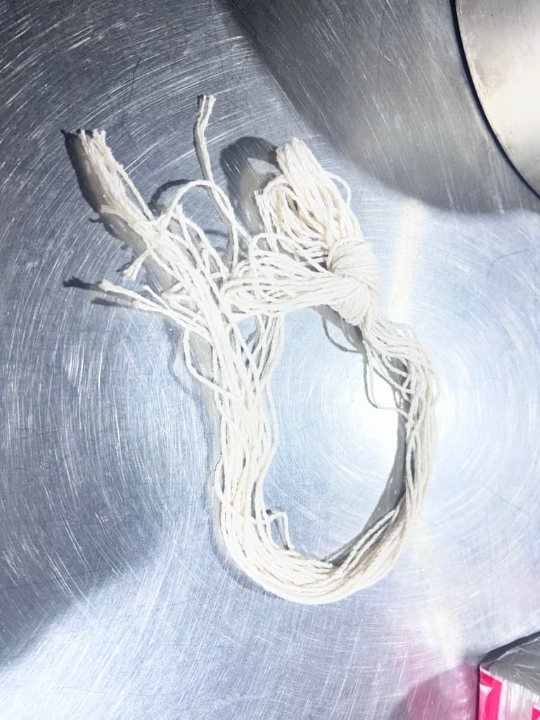 一束白色棉線綁材放在金屬檯面