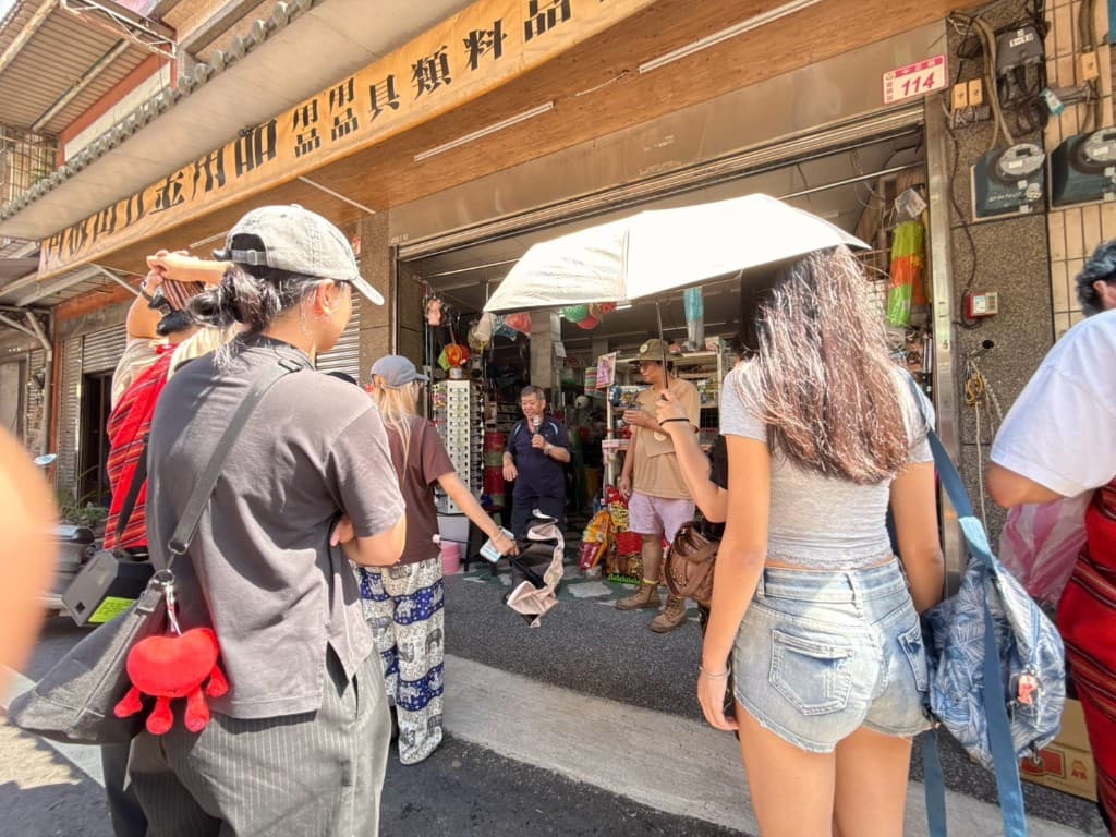 學生站在日旺五金店前,聽余老闆分享兒時生活、街區與店舖記憶
