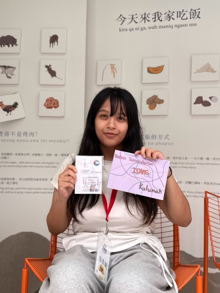 學生拿著寫有 Bahun Takisahatan、ISIANG、Kulumah 的學習卡片